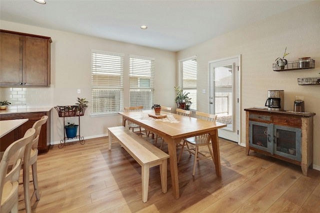 dining space featuring baseboards, light wood-type flooring, and recessed lighting