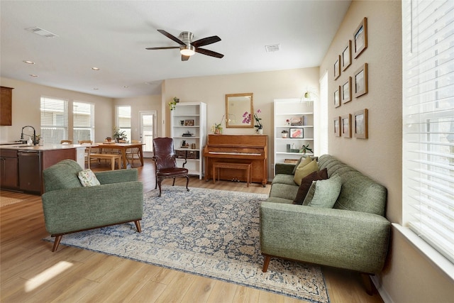 living room with light wood-style flooring, visible vents, ceiling fan, and recessed lighting