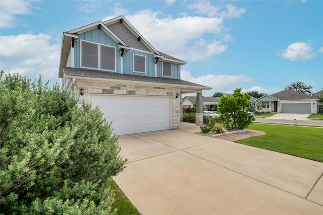 craftsman-style home with a garage, concrete driveway, stone siding, board and batten siding, and a front yard