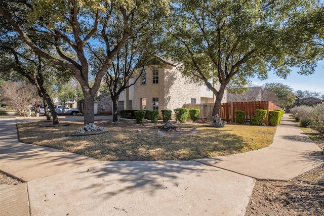 view of front of property with stone siding and fence