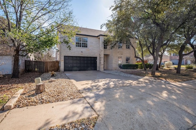 traditional-style home featuring stone siding, driveway, an attached garage, and fence