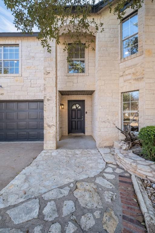 view of front of home featuring a garage and stone siding