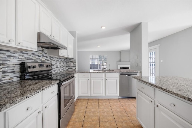 kitchen featuring backsplash, stainless steel appliances, under cabinet range hood, a sink, and light tile patterned flooring