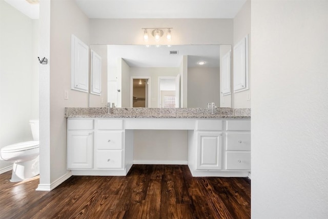 full bathroom featuring double vanity, baseboards, visible vents, toilet, and wood finished floors