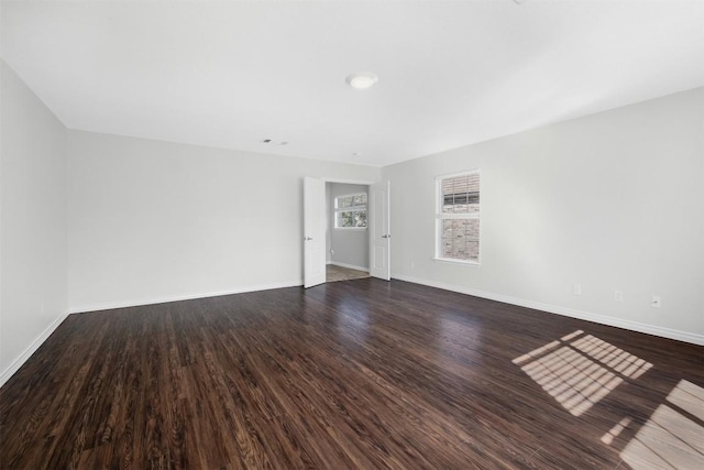 empty room featuring baseboards and wood finished floors