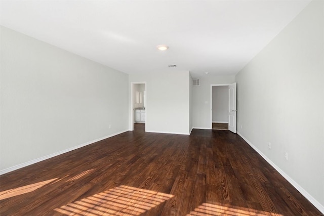 interior space featuring dark wood-style flooring, visible vents, and baseboards