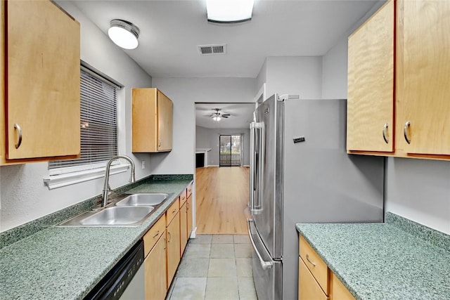 kitchen featuring visible vents, a ceiling fan, freestanding refrigerator, light tile patterned flooring, and a sink