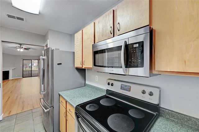 kitchen with a fireplace, light tile patterned floors, visible vents, appliances with stainless steel finishes, and a ceiling fan