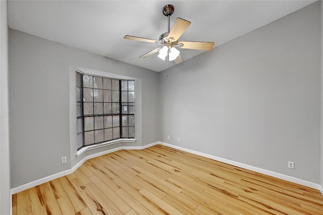 unfurnished room featuring a ceiling fan, baseboards, and wood finished floors