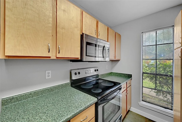 kitchen with baseboards and appliances with stainless steel finishes