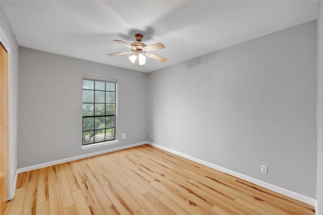 spare room featuring a ceiling fan, baseboards, and wood finished floors