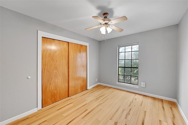 unfurnished bedroom with ceiling fan, a closet, baseboards, and wood finished floors