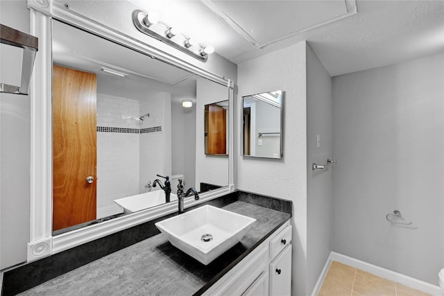 full bath featuring baseboards, a shower, tile patterned flooring, a textured ceiling, and vanity