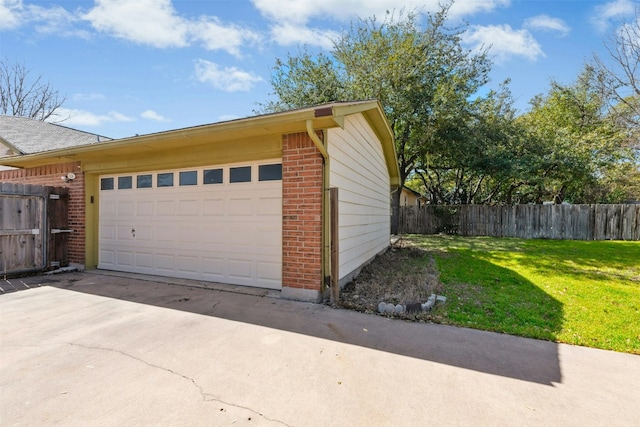 garage featuring concrete driveway and fence