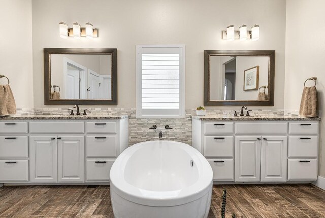 13525 Queen Johanna Ct, Corpus Christi, TX 78418 - bathroom featuring two vanities, a freestanding bath, and wood finished floors
