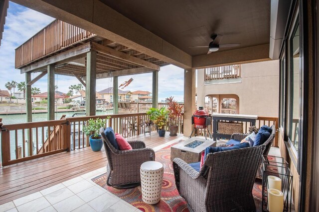13525 Queen Johanna Ct, Corpus Christi, TX 78418 - deck with a fire pit, a ceiling fan, a residential view, and a water view