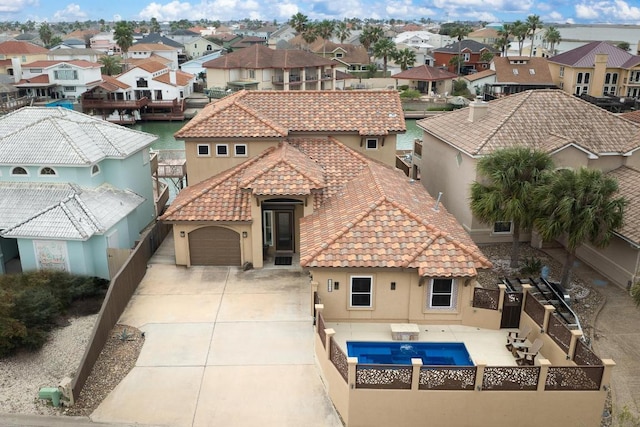 exterior space with a residential view, concrete driveway, a tiled roof, and stucco siding