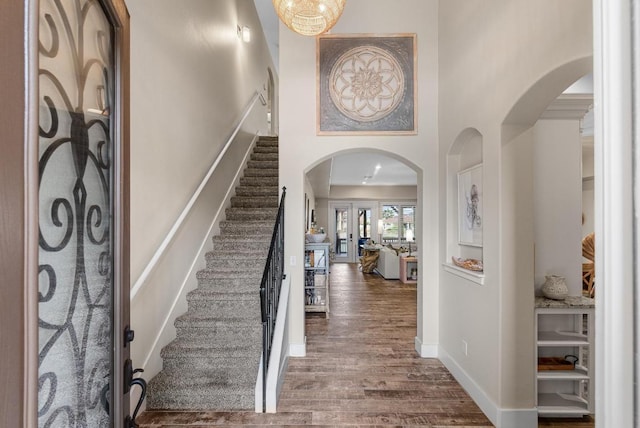 13525 Queen Johanna Ct, Corpus Christi, TX 78418 - foyer featuring dark wood finished floors, arched walkways, a towering ceiling, and stairway