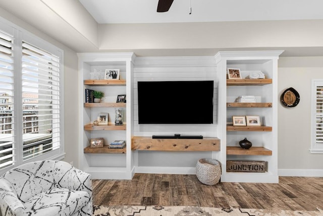 living room with built in features, ceiling fan, baseboards, and wood finished floors