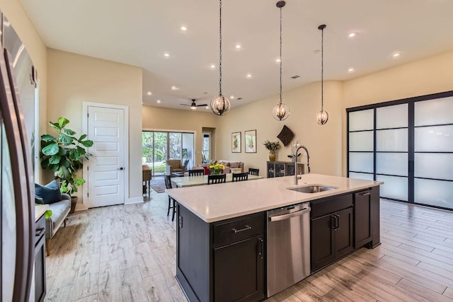 kitchen featuring light wood-type flooring, open floor plan, dishwasher, and a sink