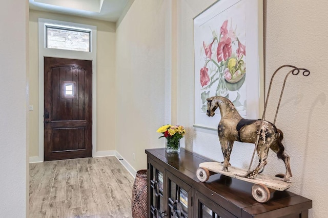 foyer featuring light wood finished floors and baseboards