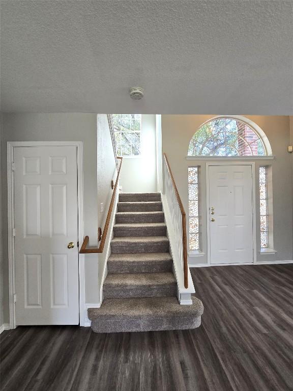 4533 Corran Ferry Loop, Austin, TX 78749 - foyer entrance featuring wood finished floors, stairway, healthy amount of natural light, and a textured ceiling