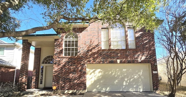 view of front of home with a garage, brick siding, and driveway