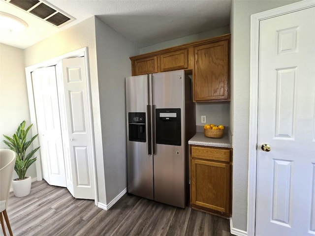 4533 Corran Ferry Loop, Austin, TX 78749 - kitchen featuring stainless steel fridge, dark wood-style floors, brown cabinetry, and light countertops