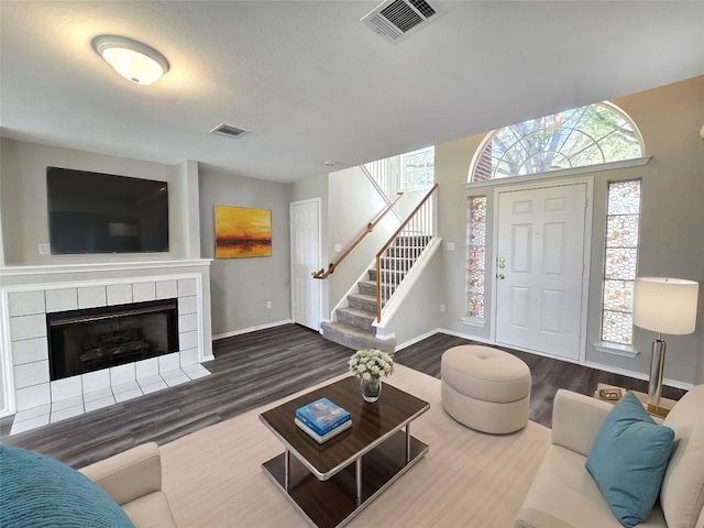 4533 Corran Ferry Loop, Austin, TX 78749 - living area with wood finished floors, stairs, plenty of natural light, and a tile fireplace