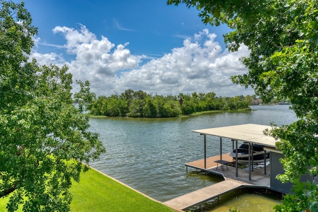 view of dock with a yard, a water view, and boat lift