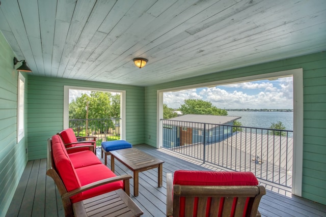 wooden deck with a water view and an outdoor living space