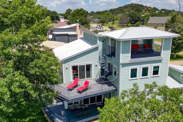 rear view of property with metal roof and stairs