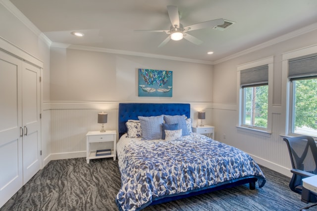 carpeted bedroom featuring a wainscoted wall, crown molding, recessed lighting, visible vents, and a ceiling fan