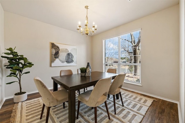 dining room featuring a chandelier, wood finished floors, and baseboards