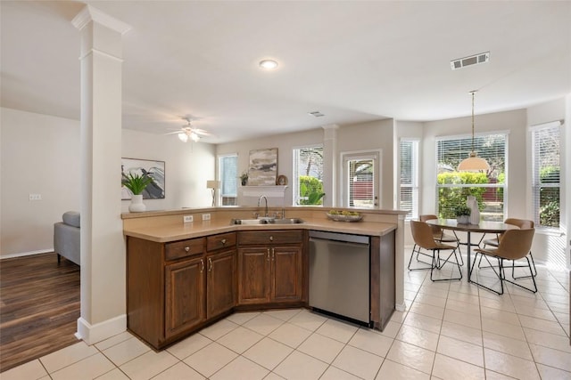 kitchen featuring a wealth of natural light, light countertops, visible vents, a sink, and dishwasher