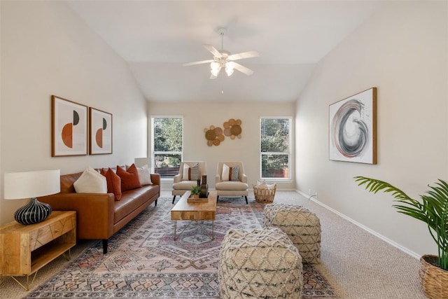 living room featuring carpet floors, vaulted ceiling, baseboards, and ceiling fan