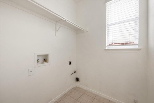 clothes washing area with light tile patterned floors, hookup for a washing machine, hookup for a gas dryer, laundry area, and baseboards