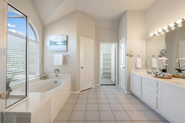 full bathroom featuring double vanity, tile patterned floors, a closet, a sink, and a bath