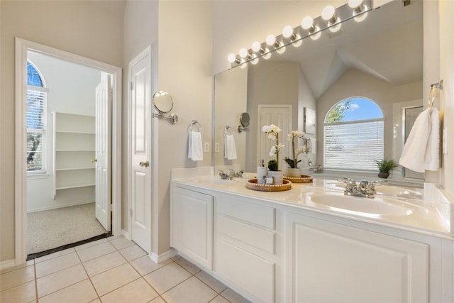 full bath with lofted ceiling, double vanity, a sink, and tile patterned floors