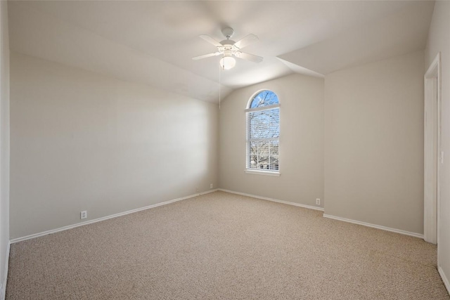 unfurnished room featuring lofted ceiling, baseboards, a ceiling fan, and light colored carpet