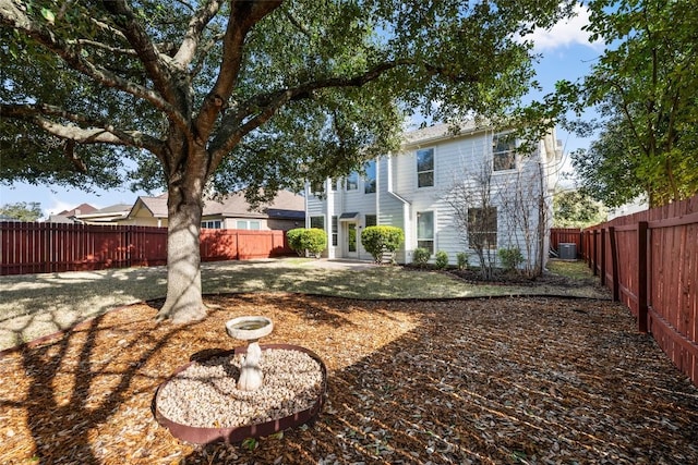 rear view of house featuring a fenced backyard and central air condition unit