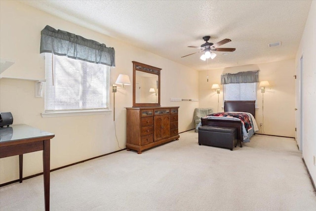 carpeted bedroom with a ceiling fan and a textured ceiling