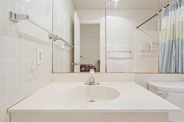 full bath with a shower with shower curtain, tile walls, and vanity