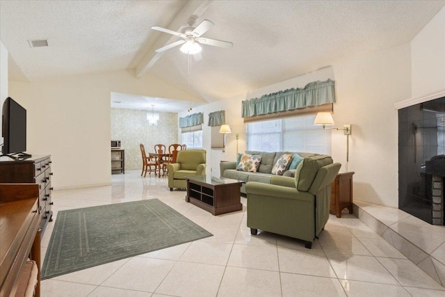 living room with vaulted ceiling with beams, ceiling fan, light tile patterned floors, a textured ceiling, and visible vents