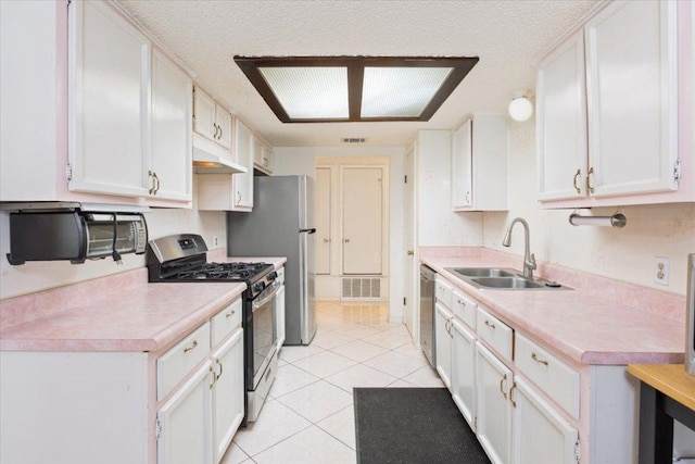 kitchen with visible vents, stainless steel appliances, a sink, and light countertops