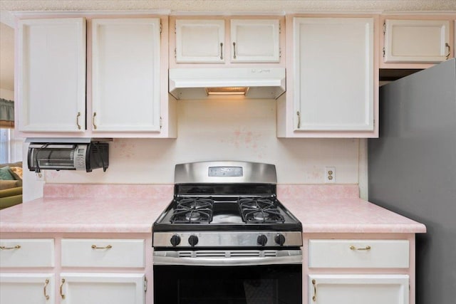 kitchen featuring stainless steel appliances, white cabinets, light countertops, and under cabinet range hood