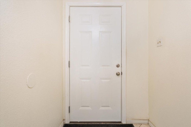 doorway featuring baseboards