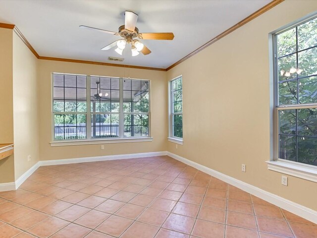 empty room with crown molding, light tile patterned flooring, baseboards, and visible vents