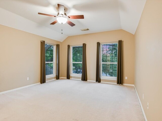 spare room featuring visible vents, baseboards, light carpet, and vaulted ceiling