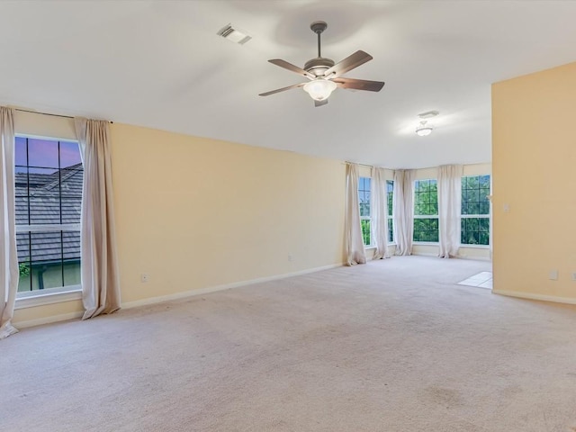 empty room featuring visible vents, baseboards, carpet, lofted ceiling, and a ceiling fan